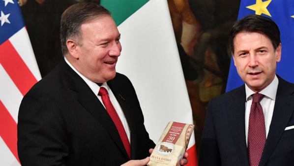 Le secrétaire d'État américain, Mike Pompeo, reçoit un morceau de fromage italien offert par un journaliste, lors de sa conférence de presse avec le Premier ministre italien, Giuseppe Conte, le 1er octobre à Rome