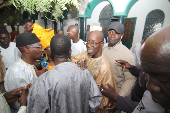 Mamadou Oumar Bocoum en tenue traditionnelle marron et montures tenant l'épaule d'un ami qui le félicitait Mamadou Oumar Bocoum en tenue traditionnelle marron et montures tenant l'épaule d'un ami qui le félicitait