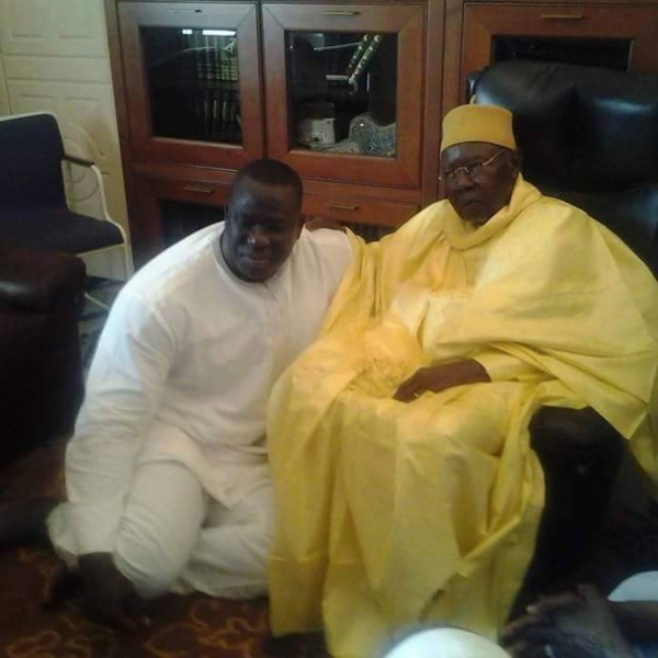Le lutteur Yekini, en vrai "talibe" Tidiane, assis aux pieds de son marabout Serigne Abdoul Aziz Sy