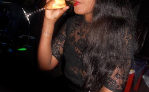 La jet-setteuse Khady Soumaré se tape un verre de champagne en boîte.