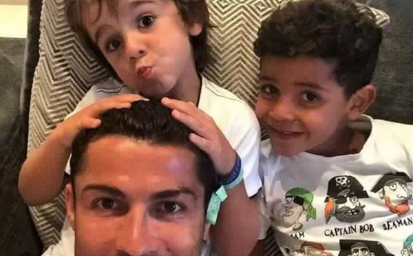 Ronaldo avec son propre enfant, avec à ses côtés, l'enfant syrien qu'il a accueilli chez lui