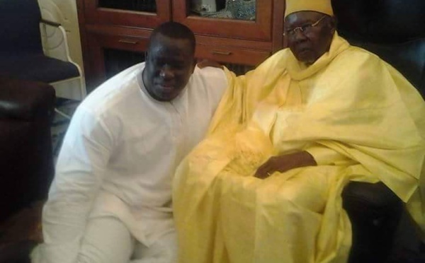 Le lutteur Yekini, en vrai "talibe" Tidiane, assis aux pieds de son marabout Serigne Abdoul Aziz Sy